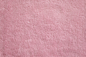Background surface of a pink, soft, terry, textured towel close-up