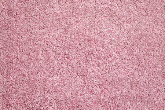 Background surface of a pink, soft, terry, textured towel close-up