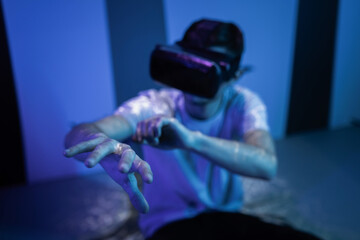 Young man wearing VR glasses sitting in a yoga pose on the virtual reality escape room floor. Fun,...