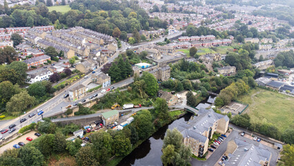 Obraz premium Arial view of a village and all the different types of building above the canal. Showing the road network on the hillside.