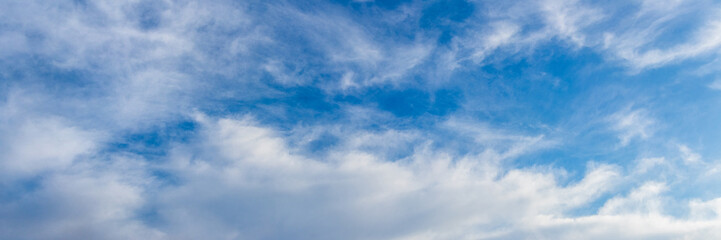 White curly clouds in the blue sky in sunny weather
