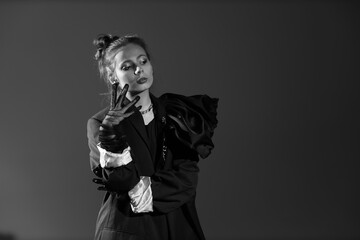 Black and white portrait of pretty young woman in black dress with gloves