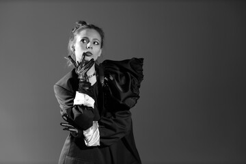 Black and white portrait of pretty young woman in black dress with gloves