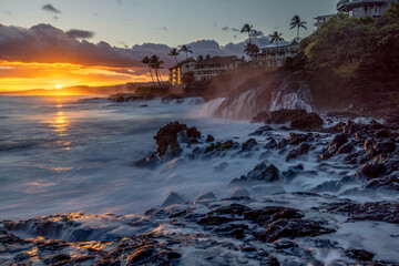 A strong wave action pushed seawater way up on the rocks and the draining back creates an interesting motion feeling as the sun is setting over the ocean, Poipu, Kauai
