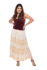 Young Indian girl wearing red velvet top and creamy and lacy long skirt with elegant pose and expression