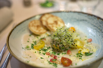 Closeup of Scallop Carpaccio in a decored plate at the restaurant