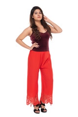 Young Indian girl wearing red velvet top and red lacy pants with elegant pose and expression