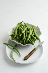 green beans in a bowl with paring knife - 704492334