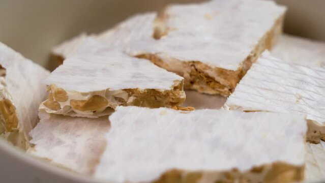 Spanish Christmas turron pieces. Delicious traditional torrone in bowl close up. Rotation