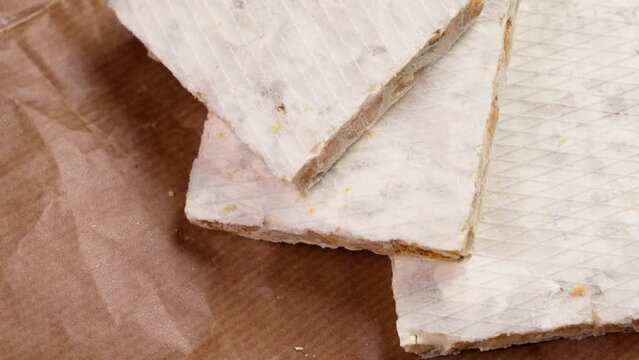 Traditional Spanish almond turron bars on a wrapping pack paper close up. Rotation