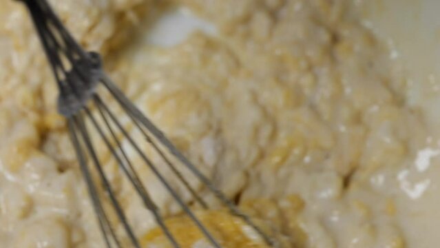 mix eggs and flour slowly. close-up of a mixture of eggs and flour. prepare crepe batter. mix egg and flour with a whisk. whisk mixing ingredients in slow motion