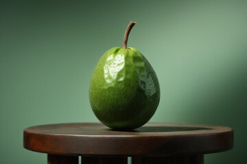 "An isolated feijoa, its green exterior standing out against a clear surface."
