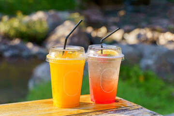 Glasses of orange juice and strawberry juice mixed with soda had thin slices of fruit. placed on top Suitable for drinking to cool off. Refreshing, welcome drink, sitting in the cafe