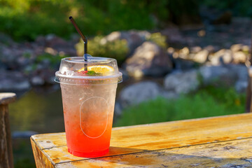 A glass of strawberry soda mixed with thinly sliced fruit. placed on top Suitable for drinking to cool off. Refreshing, welcome drink, sitting in the cafe