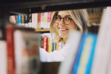 Young happy woman in a library