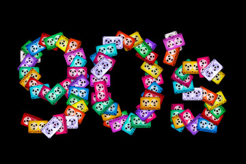 Top view of the text "90's" on a black isolated background, composed of ancient, mixed colorful audio cassettes. The year of nostalgia for analog home audio technology of the 1990s