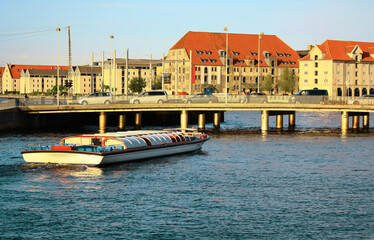 Fototapeta na wymiar Copenhagen. Denmark. A pleasure boat sails along the city canal.