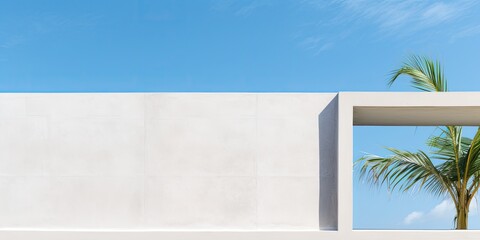 Concrete wall with open window and palm leaves against blue sky, white exterior building, modern architecture with square frame in spring/summer sky.