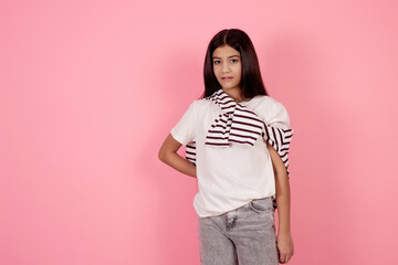 Young smiling teenage girl on pink background in studio.