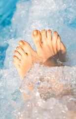 feet of the young woman during the hydromassage session to reactivate the blood circulation in the spa