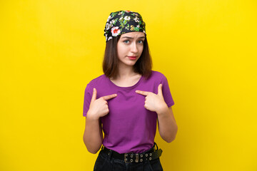 Young Ukrainian woman isolated on yellow background pointing to oneself