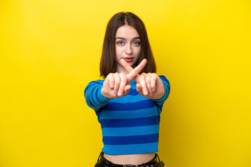 Young Ukrainian woman isolated on yellow background making stop gesture with her hand to stop an act
