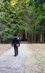 isolated woman walking and lost herself in the dirt path in the woods