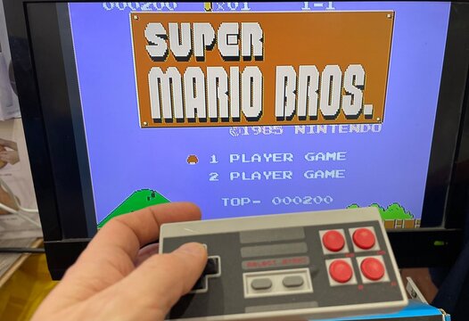 Florence, Italy, January 2nd, 2024, Person playing at Super Mario Bros, vintage game. 