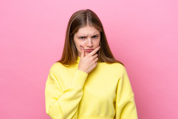 Teenager Russian girl isolated on pink background having doubts