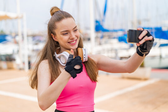 Young pretty sport girl at outdoors making a selfie with mobile phone