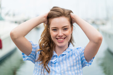 Young redhead woman at outdoors With happy expression