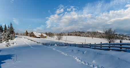 Countryside hills, groves and farmlands in winter remote alpine mountain village