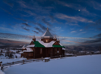 Night countryside hills, groves and farmlands in winter remote alpine mountain village. Ukraine, Voronenko.