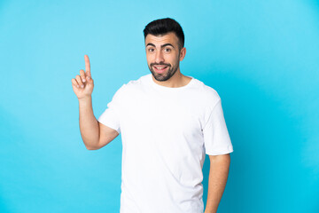 Caucasian man over isolated blue background showing and lifting a finger in sign of the best