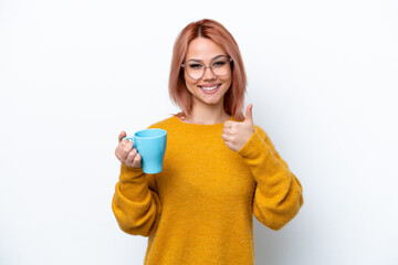 Young Russian girl holding cup of coffee isolated on white background with thumbs up because something good has happened