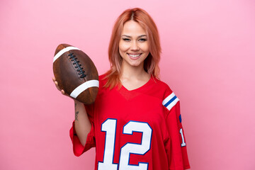 Young Russian girl playing rugby isolated on pink background smiling a lot