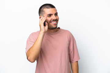 Young caucasian man isolated on white background keeping a conversation with the mobile phone