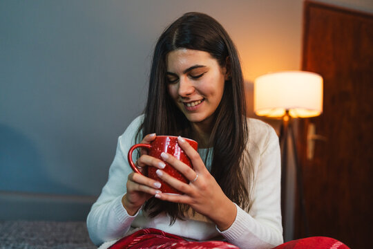 A Young Girl Or Woman Getting Up From Bed Drinking Coffee Or Tea In Blanket Cozy Room