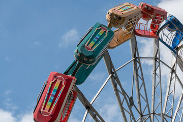 Ferris wheel vortex against blue sky in amusement park