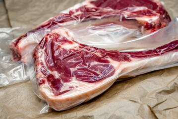Obraz premium fresh beef in vacuum packaging on a background of kraft paper