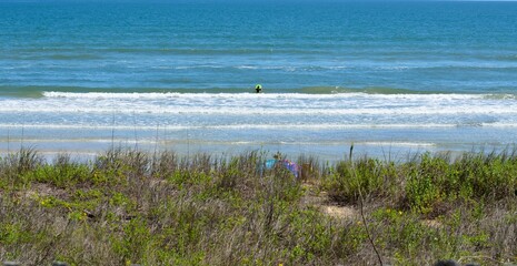 Lone surfer at a distance surfing in the ocean Florida.