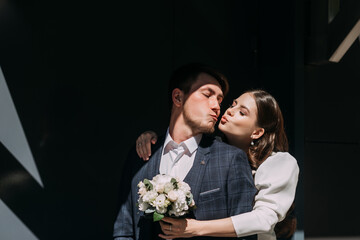 A man and woman kissing. They are outdoors and the woman is holding a flower 5034.