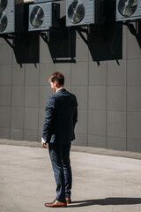 A man standing in front of a large speaker outdoors 5046.