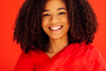 Close up of portrait of cheerful beautiful young girl with afro hairstyle in red casual clothes