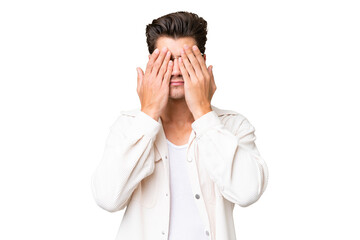 Fototapeta premium Young handsome caucasian man over isolated background covering eyes by hands