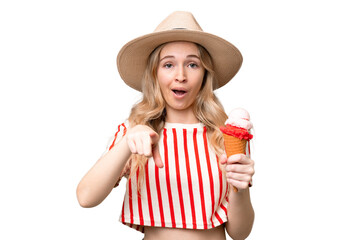Young English woman with a cornet ice cream over isolated background surprised and pointing front