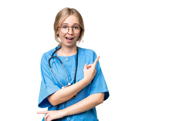 Young nurse English woman over isolated background surprised and pointing side