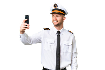 Airplane pilot man over isolated background making a selfie © luismolinero