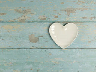 Heart shaped plate on vintage wooden background. Top view. - 704561138