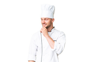 Young caucasian chef over isolated chroma key background looking to the side